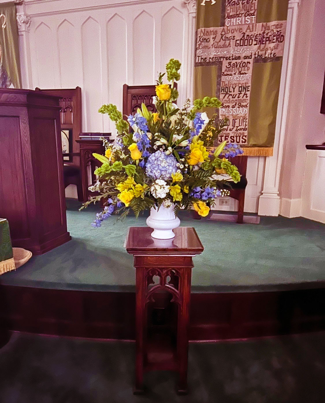 Blue hydrangea and yellow rose altar arrangement for a church service